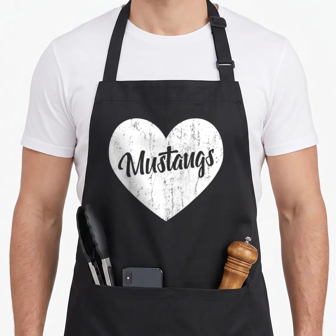 Sport mustang apron - White distressed heart containing grey cursive Mustangs text — shown on a black cotton canvas apron against a white background