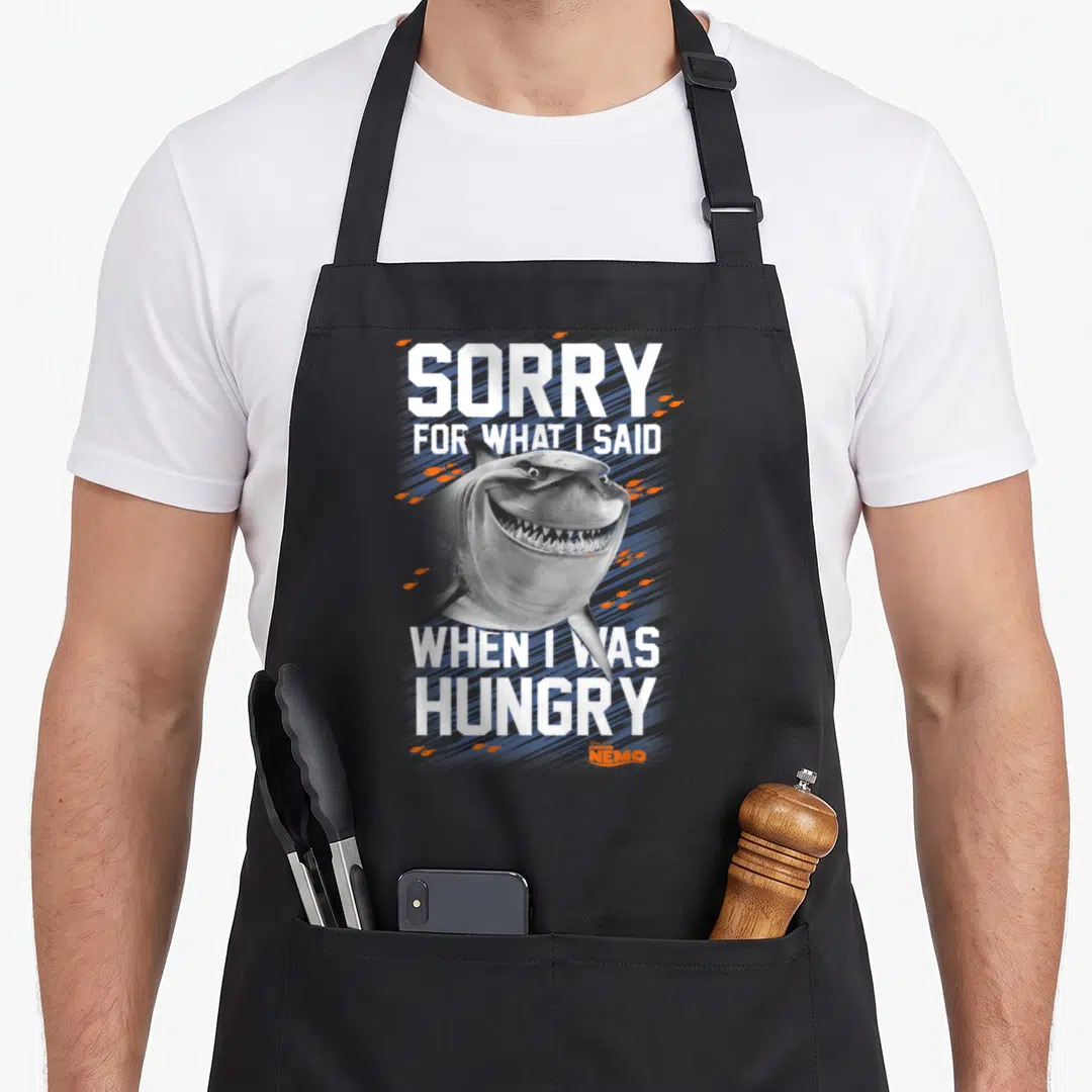 Bruce sorry apron - Realistic grey shark head with white text SORRY FOR WHAT I SAID WHEN I WAS HUNGRY and orange bubbles — shown on a black cotton canvas apron against a white background