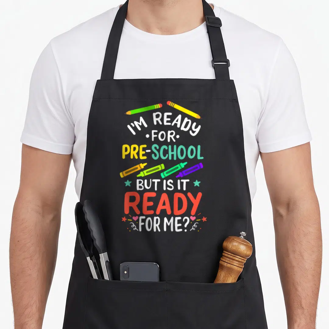 1st preschool apron - Stacked text I'M READY FOR PRE-SCHOOL BUT IS IT READY FOR ME? with pencils, crayons, stars — shown on a black cotton canvas apron against a white background