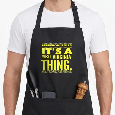 Roll pepperoni apron - Yellow stacked text reading Pepperoni Rolls Its A West Virginia Thing You Wouldnt Understand — shown on a black cotton canvas apron against a white background