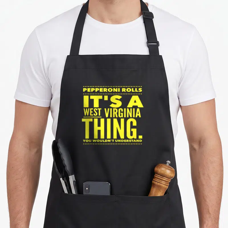 Roll pepperoni apron - Yellow stacked text reading Pepperoni Rolls Its A West Virginia Thing You Wouldnt Understand — shown on a black cotton canvas apron against a white background
