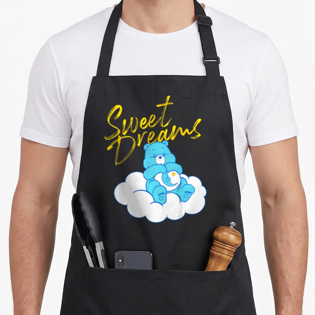Sweet care apron - Blue cartoon bear sitting on white cloud under yellow Sweet Dreams script text — shown on a black cotton canvas apron against a white background