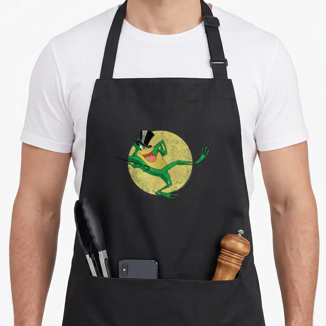 Michigan frog aprons - Green cartoon frog in black top hat holding cane over yellow circle — shown on a black cotton canvas apron against a white background