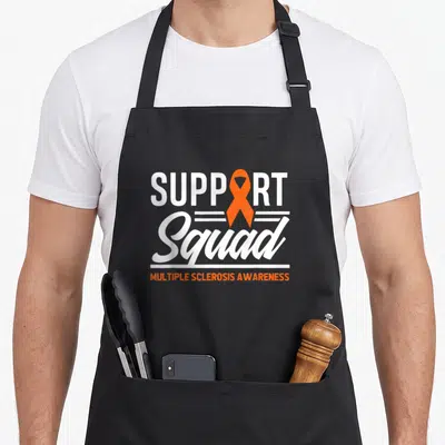 Warrior multiple sclerosis awareness apron - SUPPORT Squad text with orange ribbon replacing letter O and white lines — shown on a black cotton canvas apron against a white background
