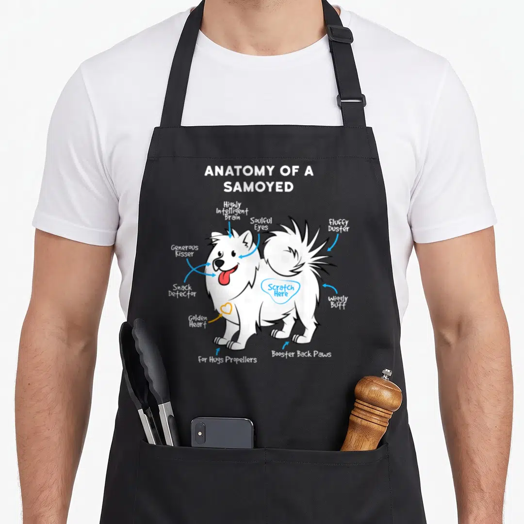 Samoyed dog apron - Cartoon white Samoyed labeled with blue arrows pointing to body parts like Golden Heart and Fluffy — shown on a black cotton canvas apron against a white background