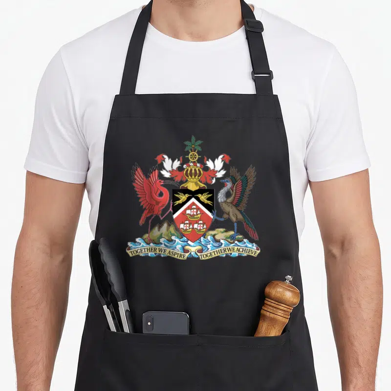 Coat trinidad and tobago apron - Trinidad Tobago coat of arms with red ibis, wood bird, ships, and TOGETHER WE ASPIRE — shown on a black cotton canvas apron against a white background