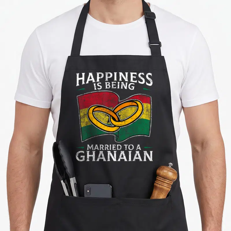Ghanaian heritage aprons - Distressed text around waving flag with two interlocking rings in red yellow green white — shown on a black cotton canvas apron against a white background