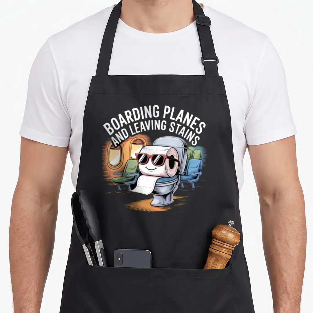 Plane boarding apron - Toilet paper roll wearing sunglasses inside a toilet with arched text BOARDING PLANES — shown on a black cotton canvas apron against a white background
