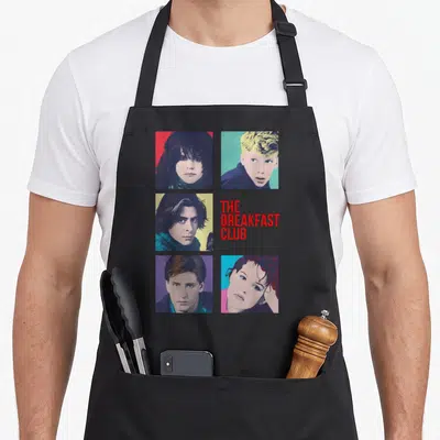 Breakfast square apron - Four portrait squares in red purple blue and yellow surrounding red stacked text — shown on a black cotton canvas apron against a white background