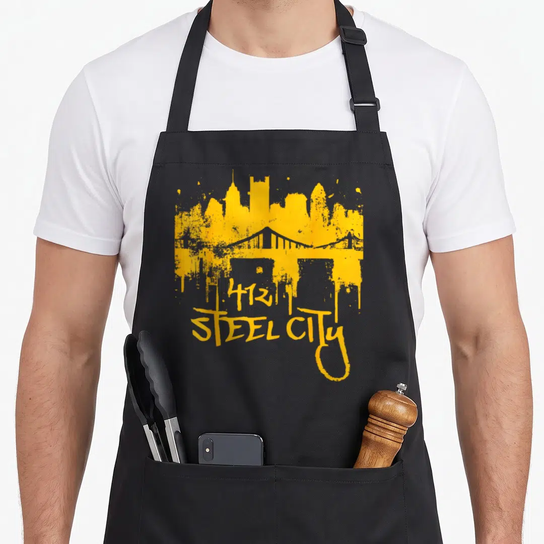 Steel city skyline apron - Distressed yellow 412 STEEL CITY skyline and bridge silhouette on black apron — shown on a black cotton canvas apron against a white background