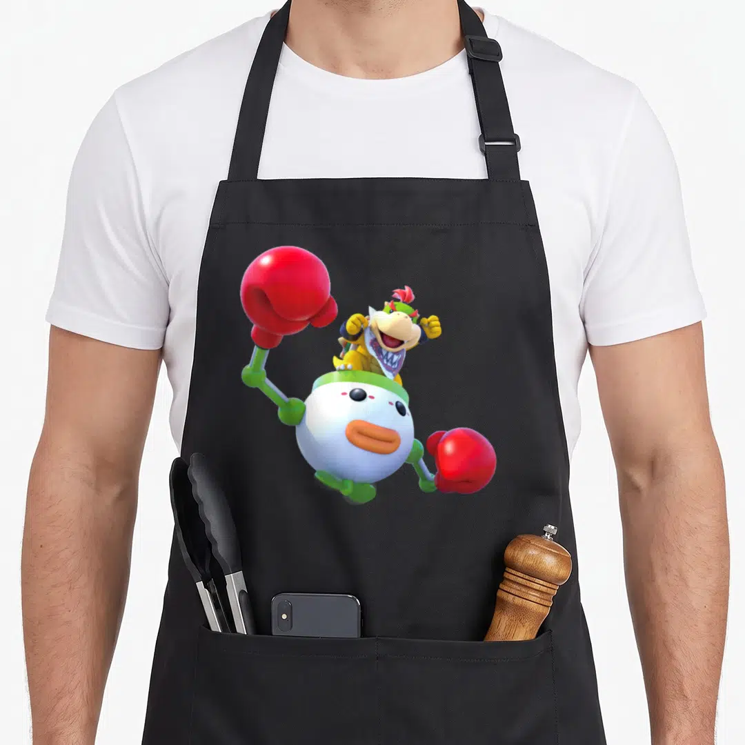 Baby clown aprons - Bowser Jr. riding white robot with two red boxing gloves in 3D style — shown on a black cotton canvas apron against a white background