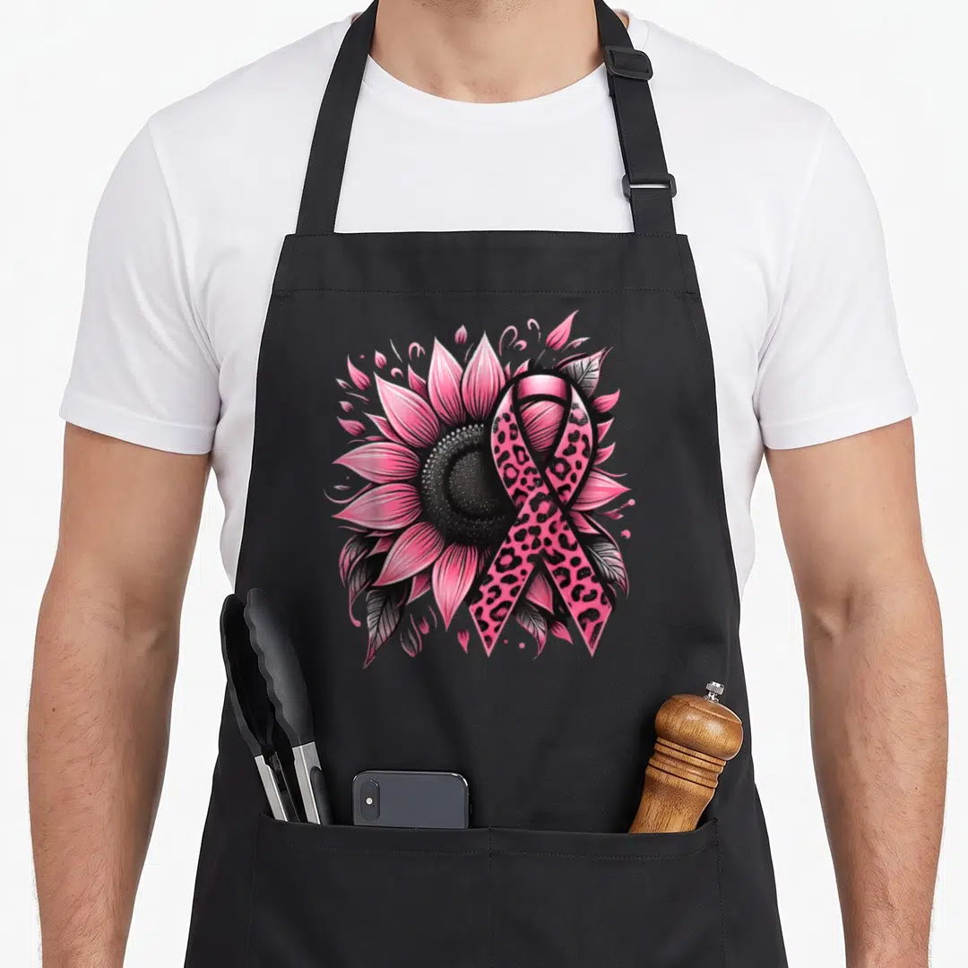 Funny sunflower breast cancer awareness aprons - Pink sunflower with leopard print awareness ribbon and black leaves — shown on a black cotton canvas apron against a white background