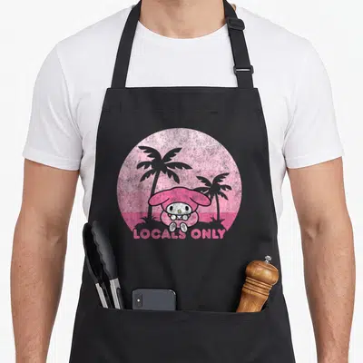 Local my melody apron - My Melody sits before two grey palm trees in a pink striped circle with LOCALS ONLY text below — shown on a black cotton canvas apron against a white background