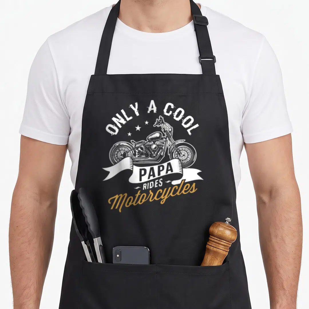 Fan motorcycle apron - White and gold graphic of a chopper bike with text Only A Cool Papa Rides Motorcycles — shown on a black cotton canvas apron against a white background