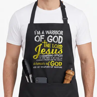 Warrior funny christian aprons - Yellow cross and white distressed text reading I am warrior of God Jesus commanding — shown on a black cotton canvas apron against a white background