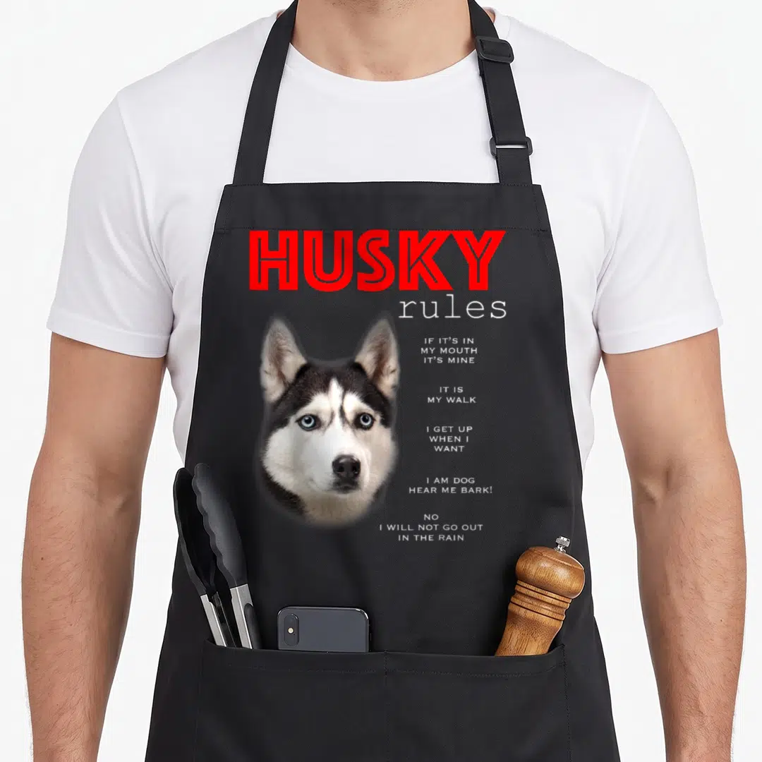 Rule husky apron - Husky head photo with red HUSKY rules text and white list on black apron — shown on a black cotton canvas apron against a white background