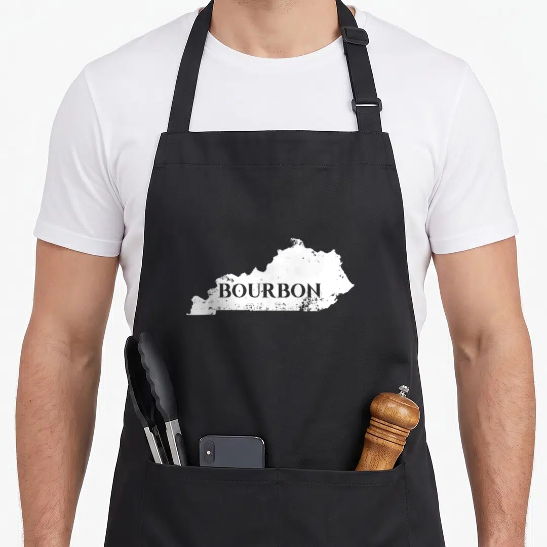 Kentucky bluegrass apron - White Kentucky state map silhouette with grey BOURBON text in distressed print style — shown on a black cotton canvas apron against a white background
