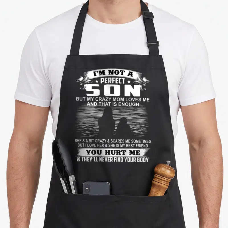 Perfect but mom and son aprons - Stacked white text and distressed silhouette on grey background — shown on a black cotton canvas apron against a white background