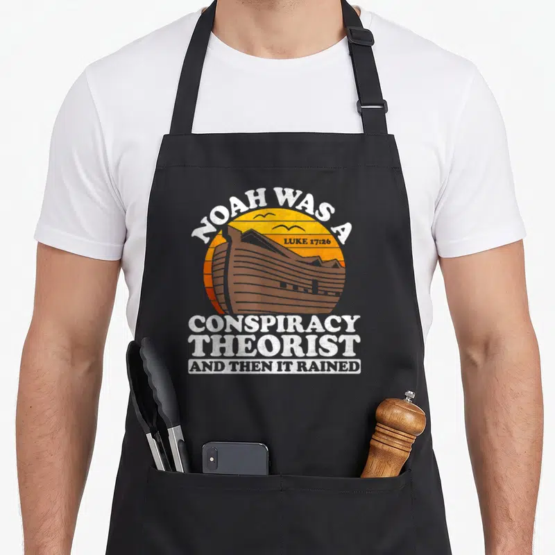 Conspiracy christian apron - Vintage ark in orange sun with two birds and distressed white text reading Noah was — shown on a black cotton canvas apron against a white background