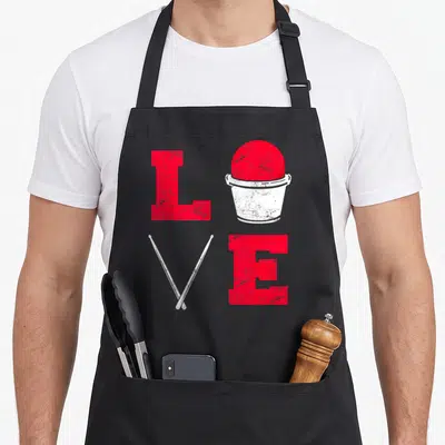 Class cardio apron - Distressed red LOVE grid with bucket ball and crossed white drumsticks — shown on a black cotton canvas apron against a white background
