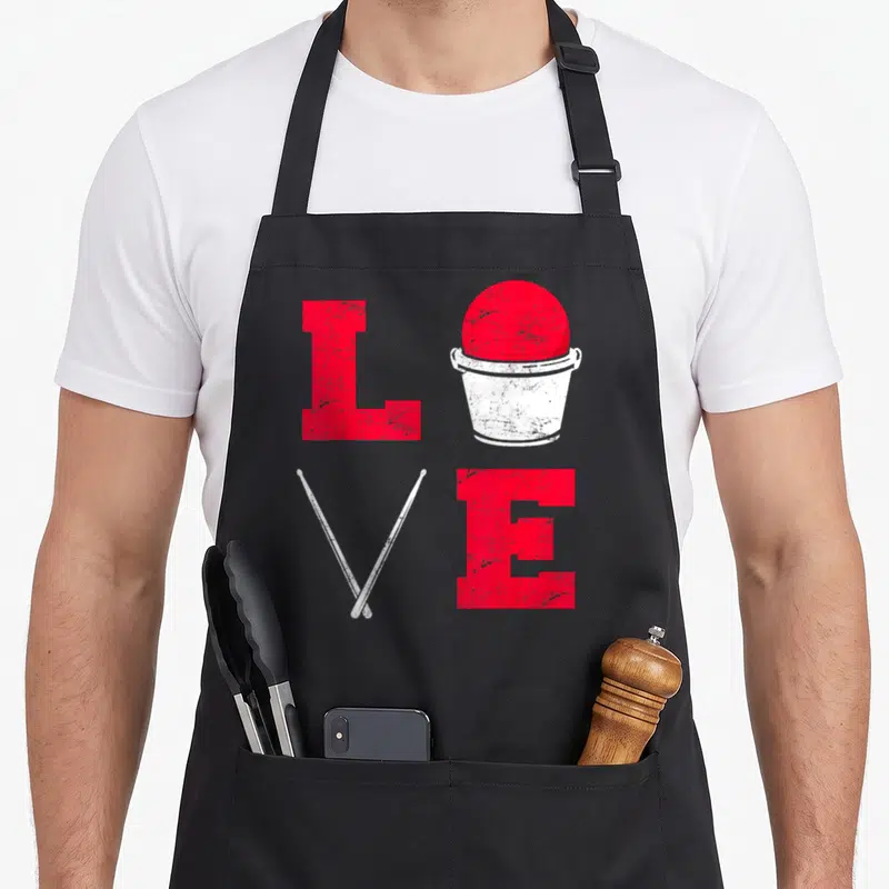Class cardio apron - Distressed red LOVE grid with bucket ball and crossed white drumsticks — shown on a black cotton canvas apron against a white background