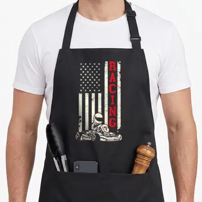 Karting american flag apron - Distressed USA flag with vertical red RACING text and go-kart driver illustration — shown on a black cotton canvas apron against a white background