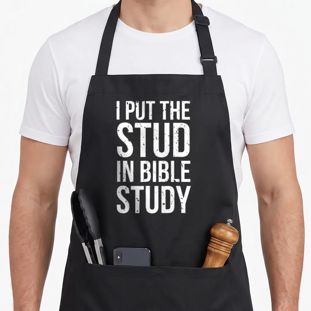 Stud christian apron - White stacked text reading I PUT THE STUD IN BIBLE STUDY — shown on a black cotton canvas apron against a white background