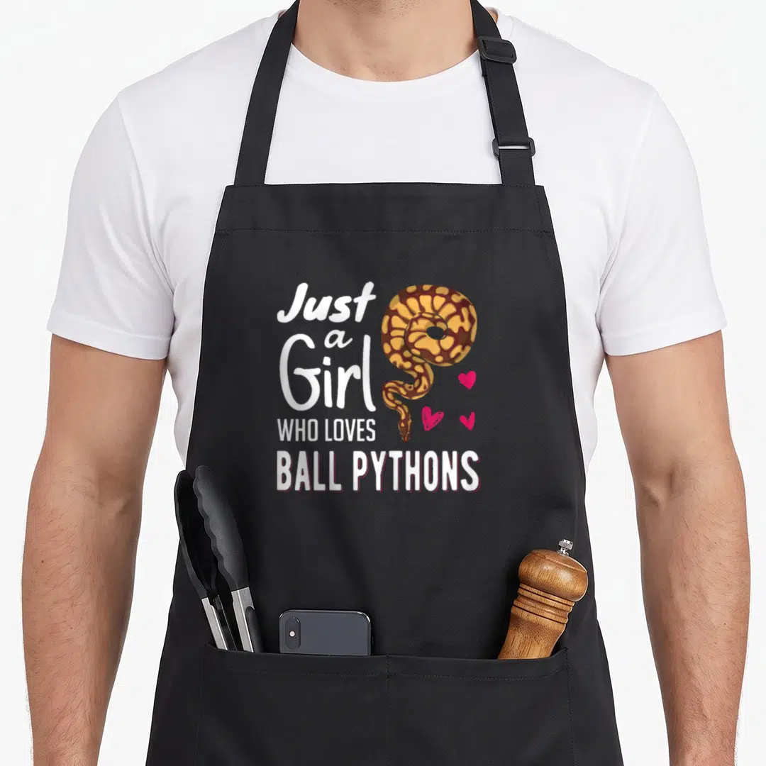 Ball snake apron - Coiled brown and yellow snake next to white text and three pink hearts — shown on a black cotton canvas apron against a white background