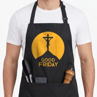 Friday christian apron - Grey Jesus silhouette on cross inside yellow circle with stacked GOOD FRIDAY text — shown on a black cotton canvas apron against a white background