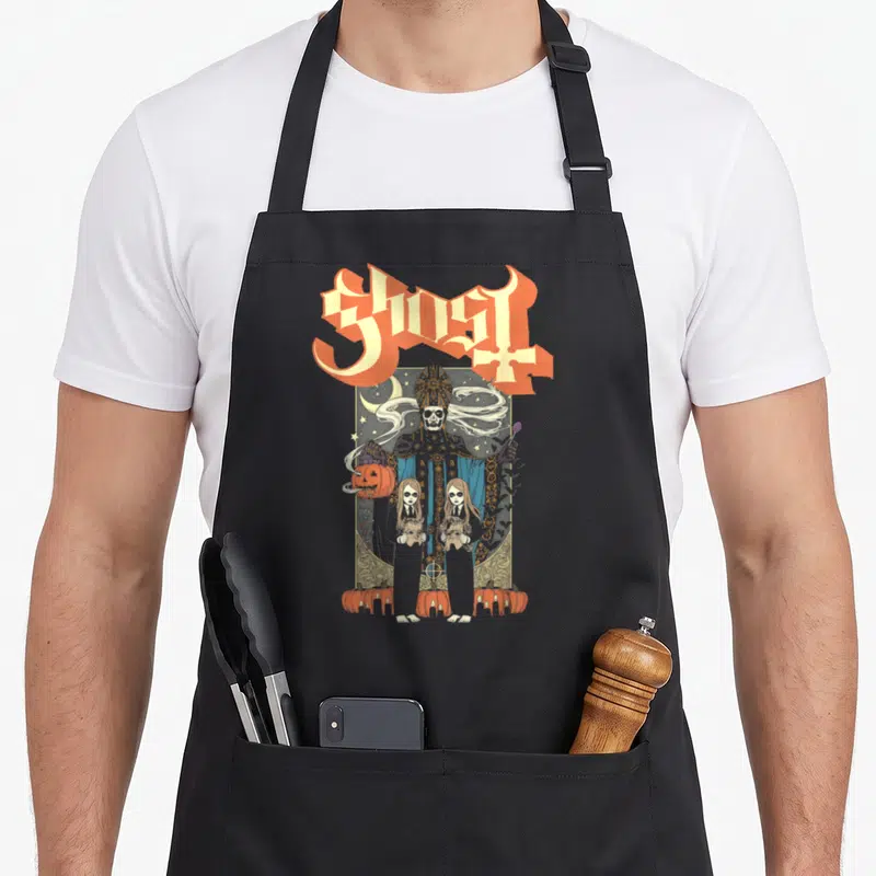 Ghost twin halloween apron - Skeleton pope in gold frame with two girls and pumpkins under arched Ghost text — shown on a black cotton canvas apron against a white background