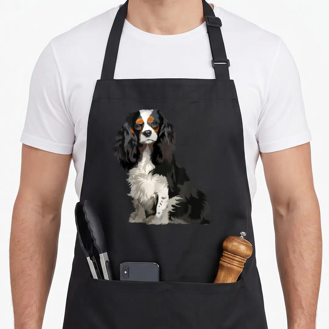 Dog king apron - Realistic tricolor dog illustration in black white and brown centered on fabric — shown on a black cotton canvas apron against a white background