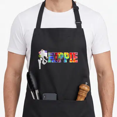 Hippie replacement hip apron - White hip bone with flowers and tie-dye HIPPIE text — shown on a black cotton canvas apron against a white background