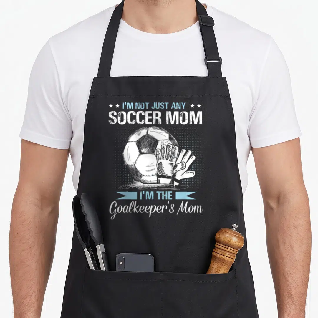 Goalkeeper mother's day aprons - Soccer ball and glove with I'm Not Just Any Soccer Mom text in white and blue — shown on a black cotton canvas apron against a white background