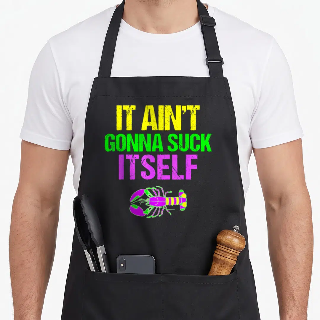 Suck mardi gras aprons - Stacked yellow green purple text IT AIN'T GONNA SUCK ITSELF above colored lobster — shown on a black cotton canvas apron against a white background