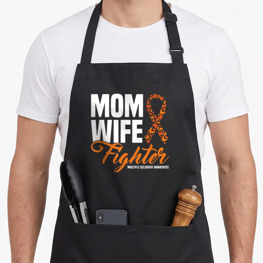 Ribbon wife apron - MOM WIFE Fighter text next to orange butterfly ribbon and MS awareness label — shown on a black cotton canvas apron against a white background