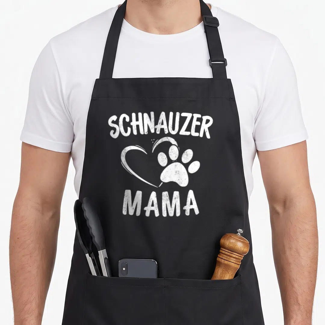 Mama dog schnauzer apron - Distressed white SCHNAUZER MAMA text with heart and paw print graphic — shown on a black cotton canvas apron against a white background