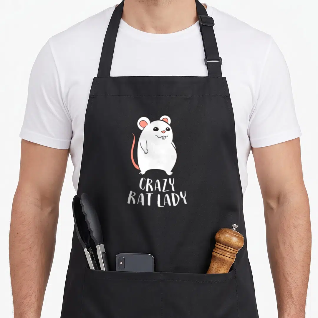 Retro crazy rat lady apron - White cartoon rat with pink ears above stacked CRAZY RAT LADY text — shown on a black cotton canvas apron against a white background