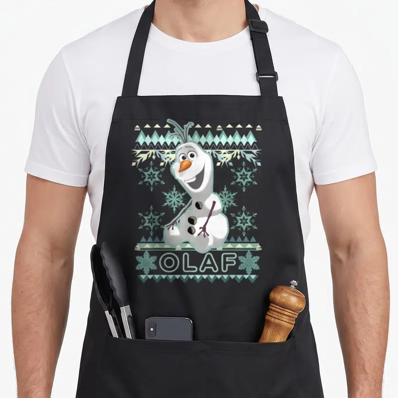 Olaf ugly christmas apron - Cartoon snowman with geometric border and stitched OLAF text in white blue orange — shown on a black cotton canvas apron against a white background