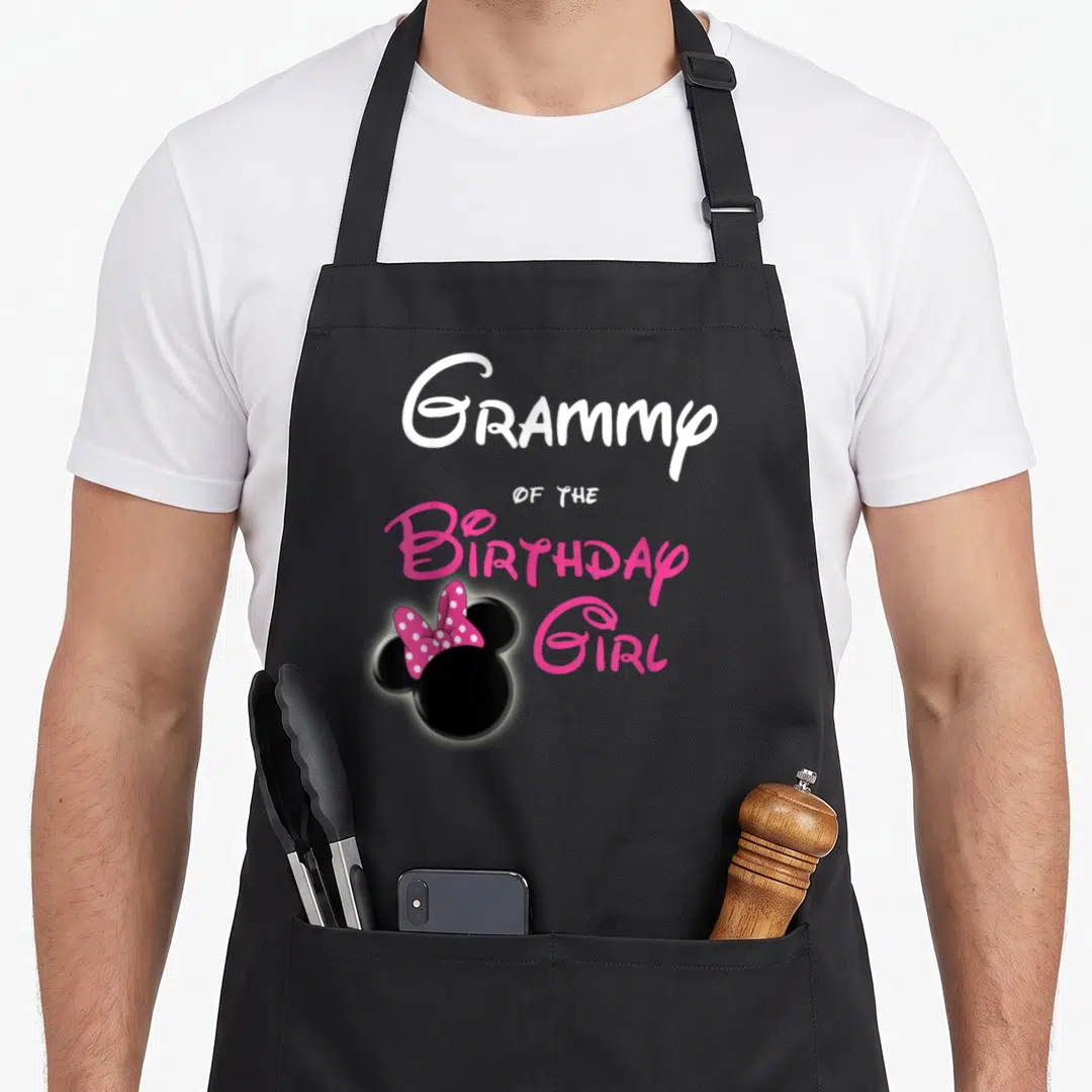 Birthday grammy apron - Stacked Grammy text with black Minnie ears and pink polka dot bow — shown on a black cotton canvas apron against a white background