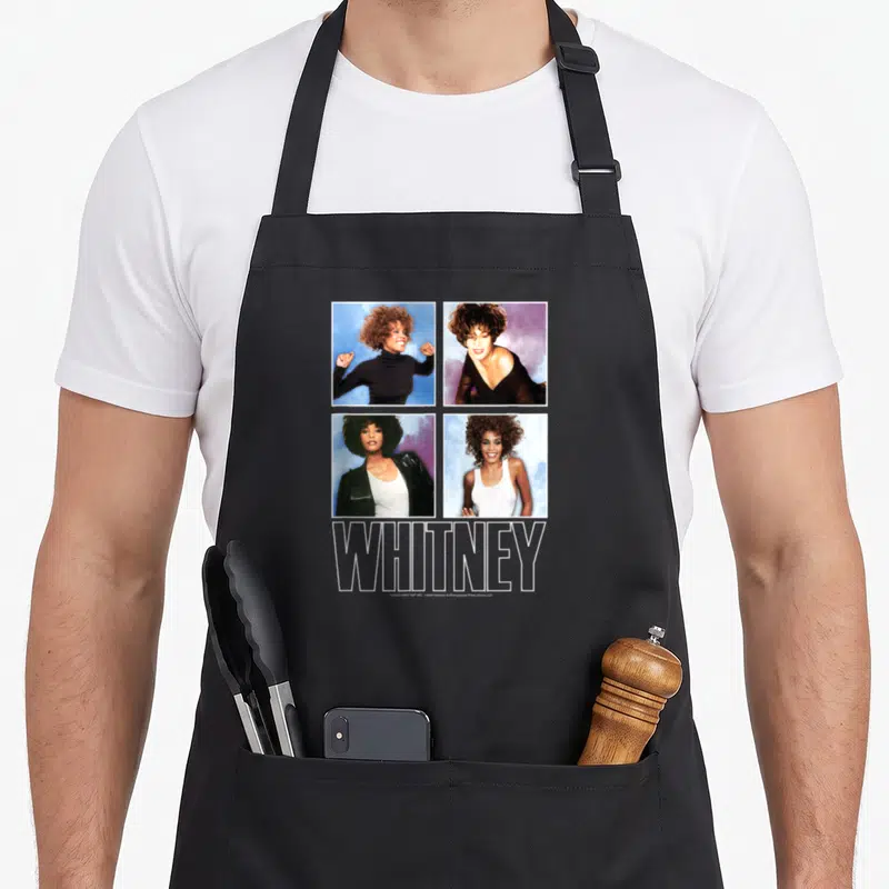 Whitney houston problem apron - Four square photos of Whitney Houston in a grid above large outlined WHITNEY text — shown on a black cotton canvas apron against a white background