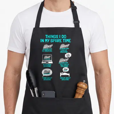 Cruising crazy cruise apron - Cyan and white graphic listing six things done in spare time related to cruise ships — shown on a black cotton canvas apron against a white background