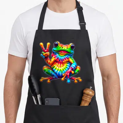 Tie hippie apron - Cartoon frog with tie-dye red yellow green blue purple skin making a peace sign — shown on a black cotton canvas apron against a white background
