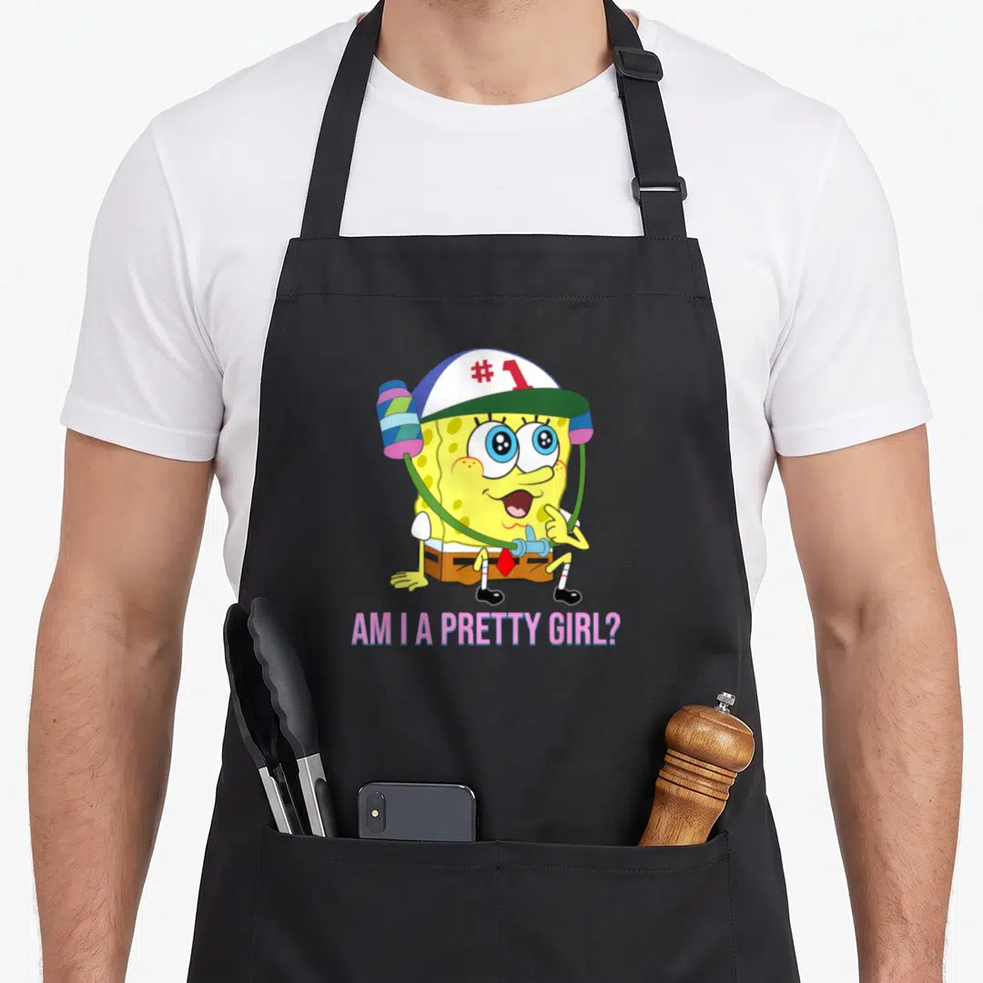 Squarepant pretty apron - SpongeBob in cap and headphones with pink text Am I a Pretty Girl below — shown on a black cotton canvas apron against a white background