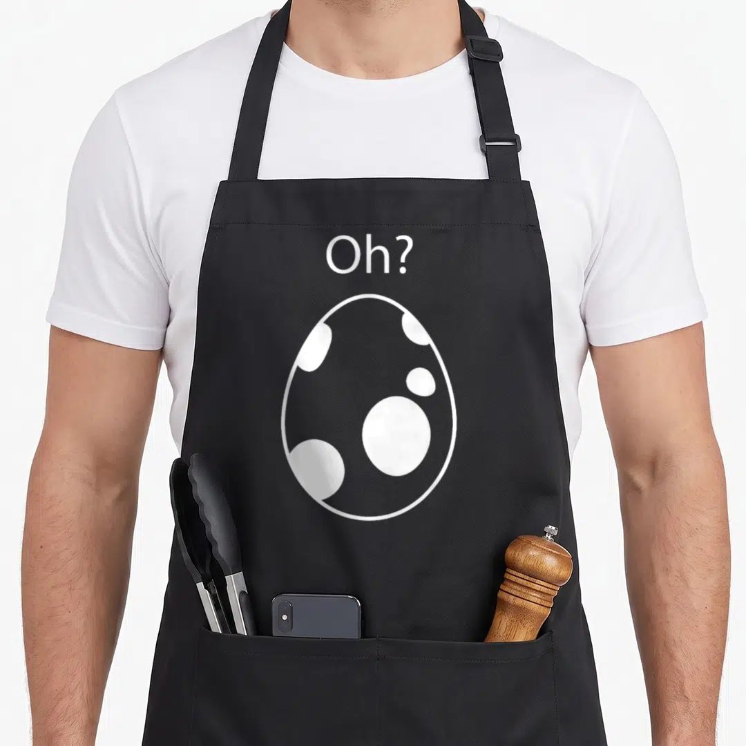 Hatching egg apron - White egg outline with internal spots and Oh? text above on black fabric — shown on a black cotton canvas apron against a white background