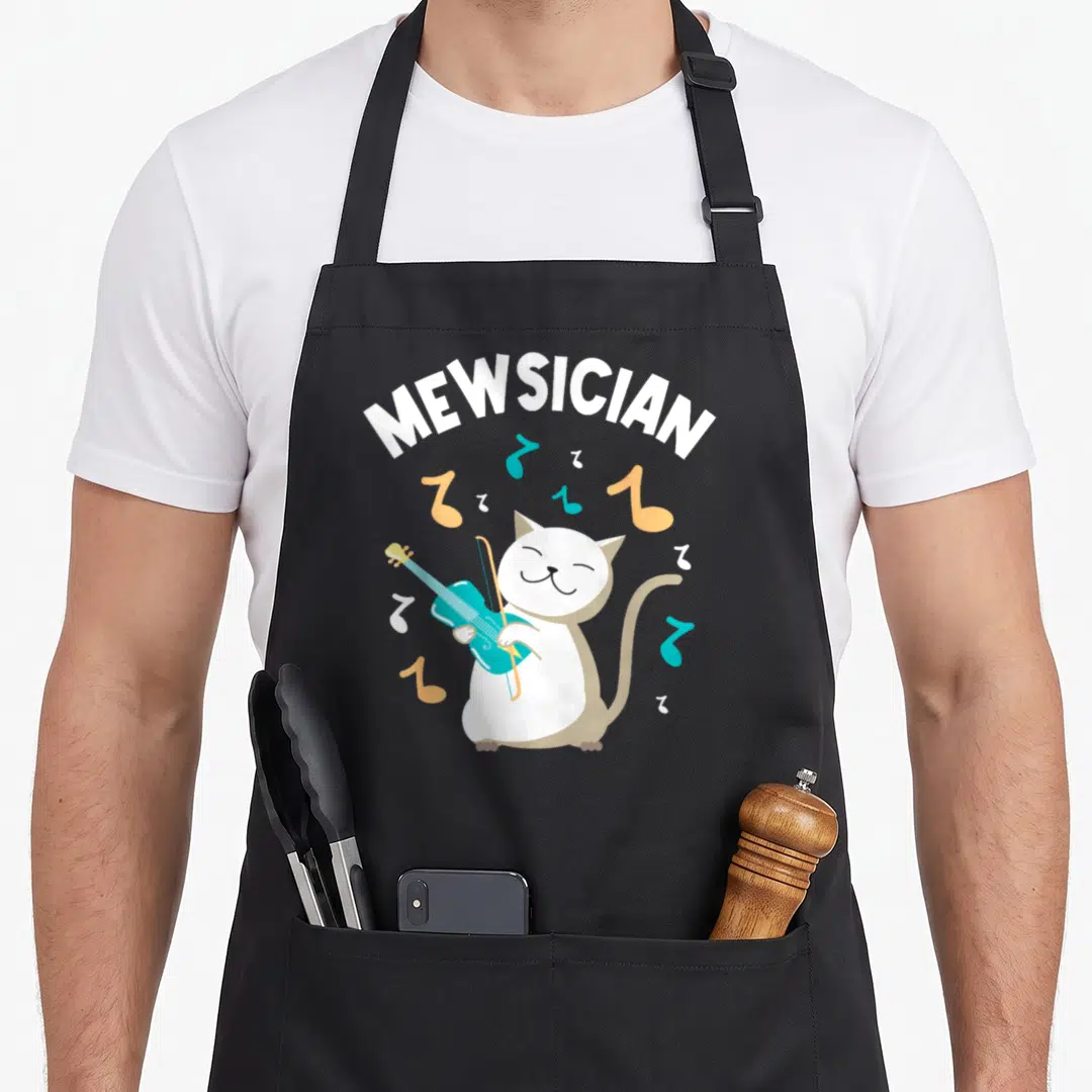 Mewsician cat apron - Cartoon white cat playing teal violin with MEWSICIAN text and scattered notes — shown on a black cotton canvas apron against a white background