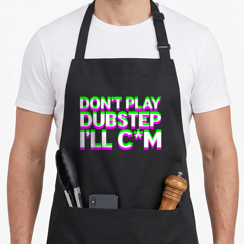 Play dubstep apron - Stacked white text with neon green and pink outlines reading DON'T PLAY DUBSTEP I'LL C*M — shown on a black cotton canvas apron against a white background