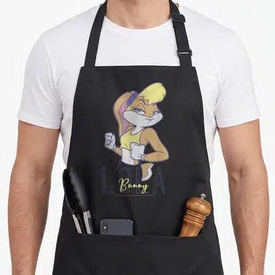 Lola bunny apron - tan cartoon rabbit with yellow top, purple outlines, LOLA outlined text, Bunny script — shown on a black cotton canvas apron against a white background