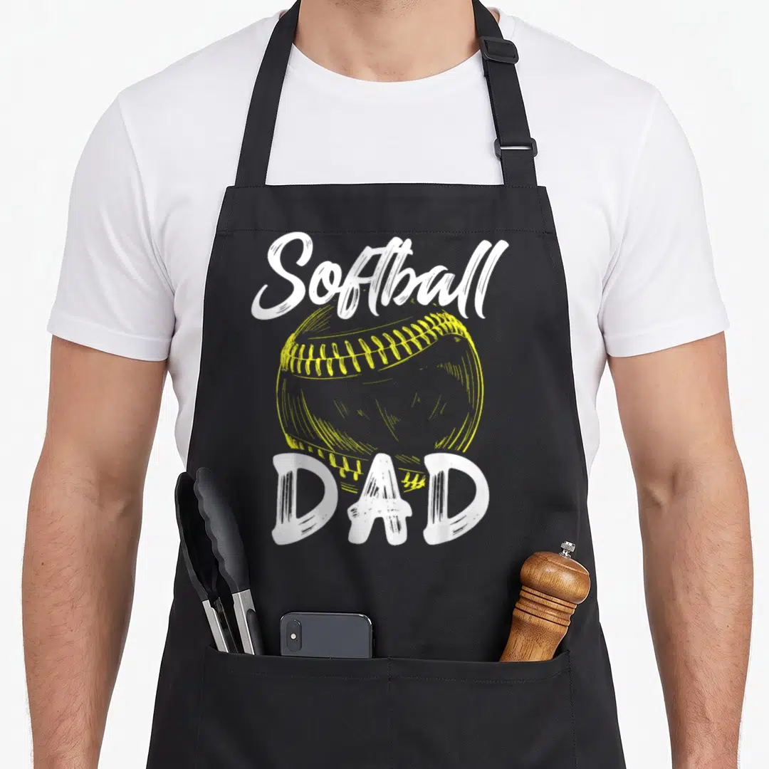 Softball family father day apron - White Softball and DAD text surrounding a yellow stitched softball illustration — shown on a black cotton canvas apron against a white background
