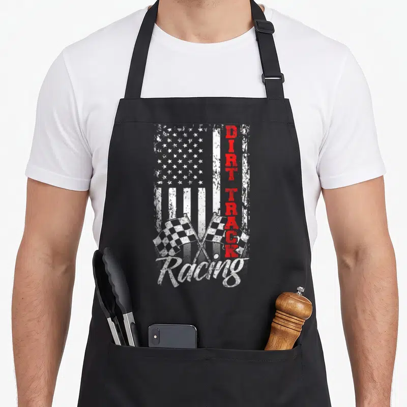Flag track apron - Distressed USA flag with red DIRT TRACK text and crossed checkered racing flags — shown on a black cotton canvas apron against a white background