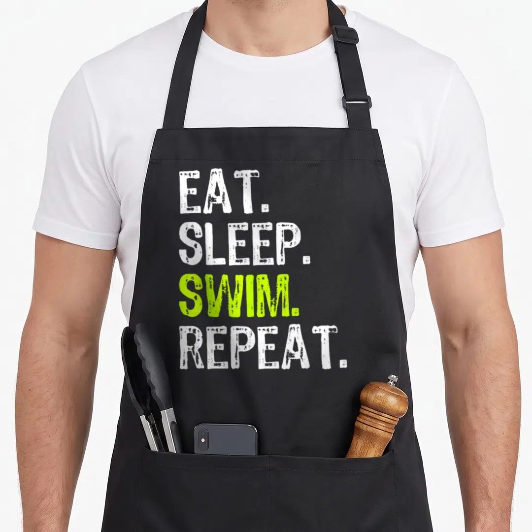 Sleep swimmer apron - Stacked distressed text EAT SLEEP SWIM REPEAT in white and lime green — shown on a black cotton canvas apron against a white background